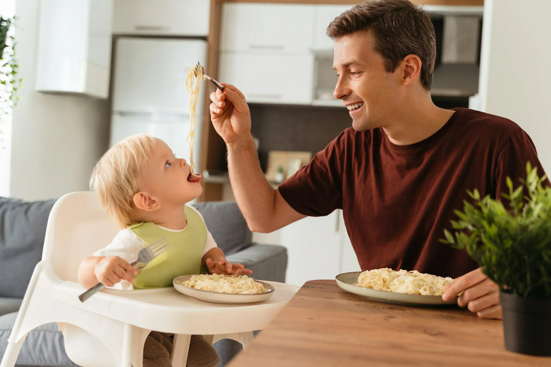Baby eating a modified version of family meal with pasta