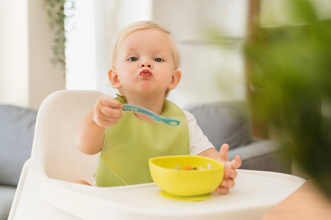 Baby eating in a familiar high chair at home as part of a feeding routine after the holidays